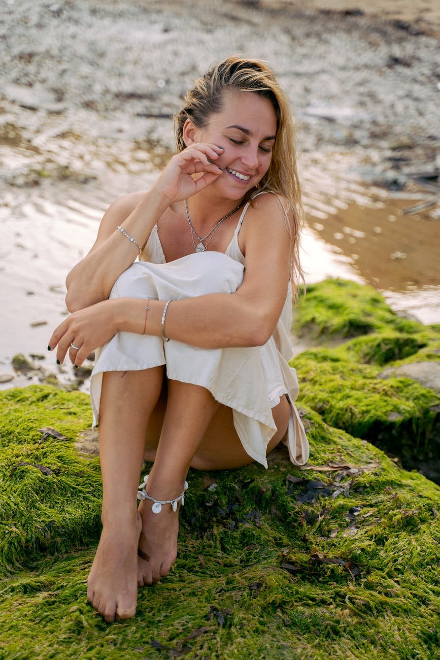 pretty woman sitting on mossy rock