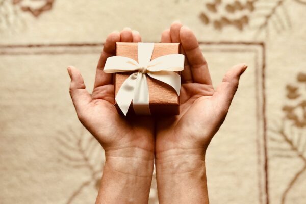 person s holds brown gift box