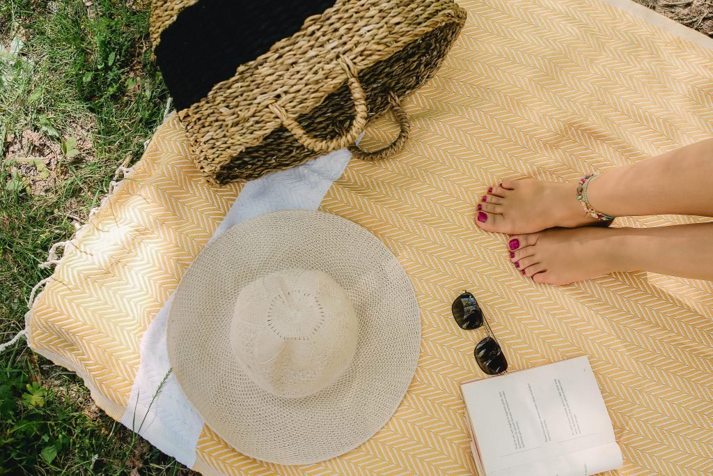 a person's feet and a hat on a blanket
