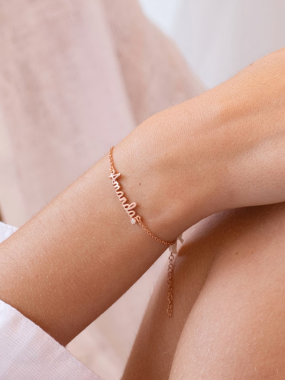 Gold engraved name bracelet worn on wrist