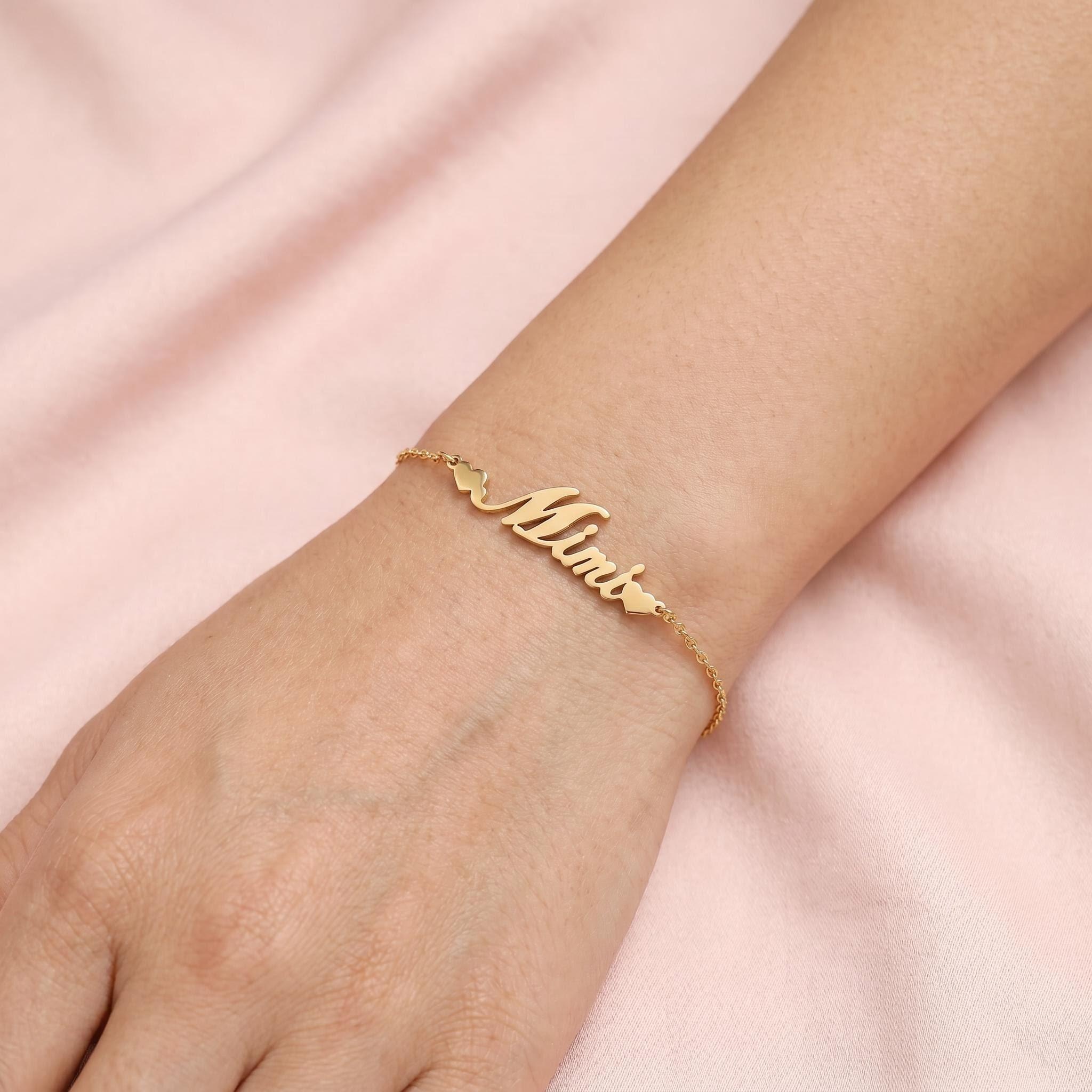 Gold name bracelet worn on wrist